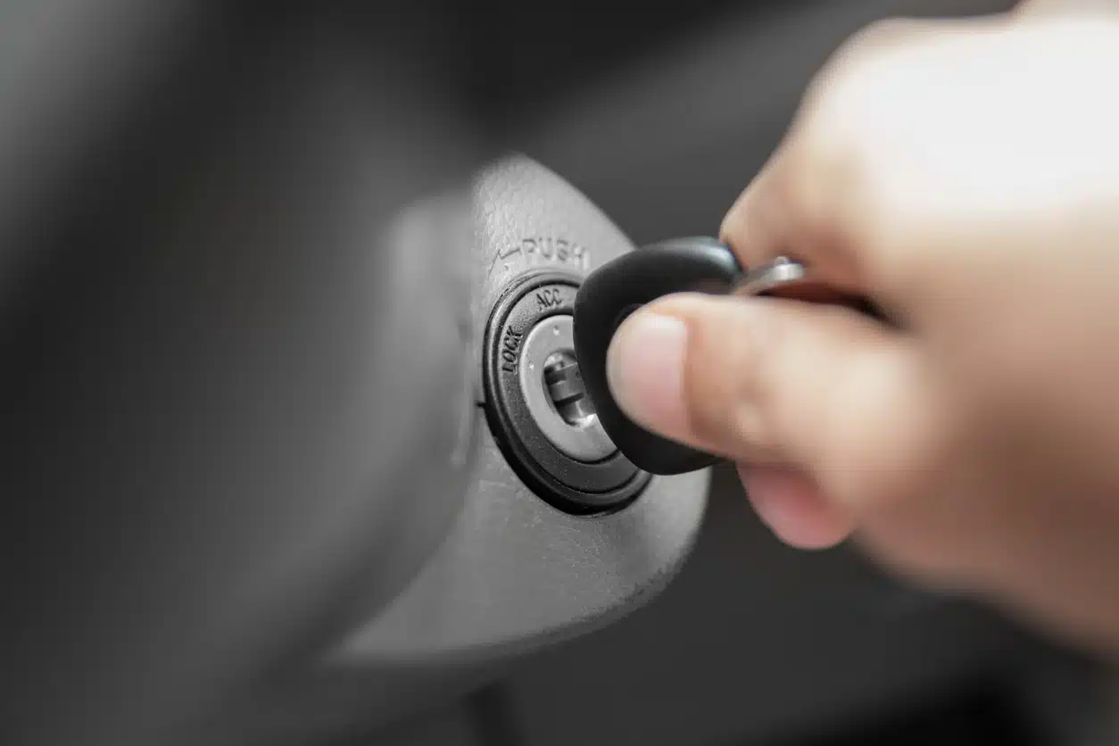 Person inserts a car key into the ignition after using ignition interlock device to ensure they’re not driving impaired.