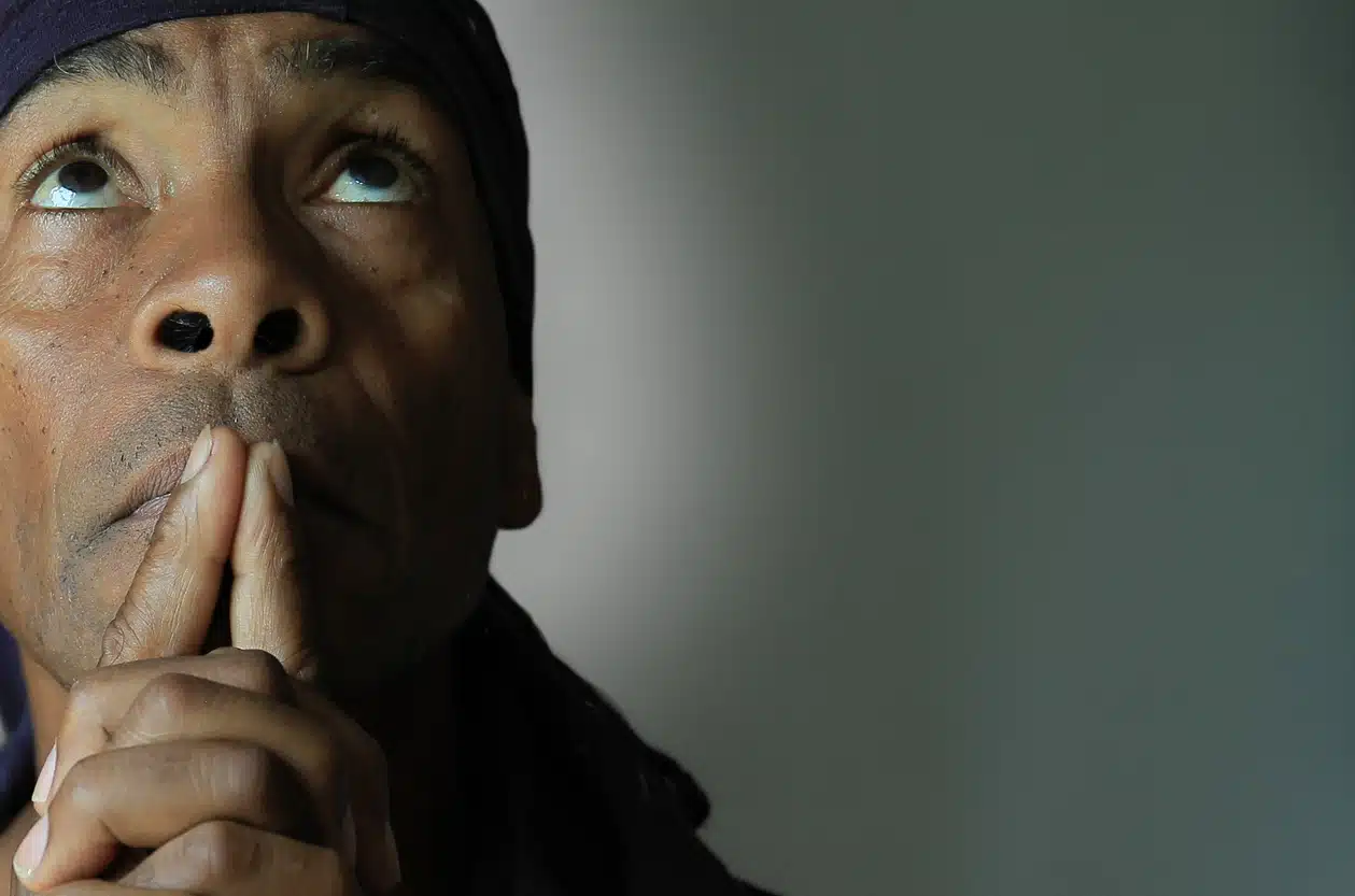 A worried man holds his fingers to his mouth during police questioning, invoking his Miranda rights in Alabama.